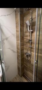 y baño con ducha y pared de madera. en Studio M, en Kopaonik