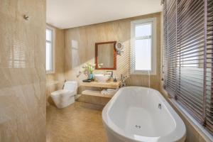 a bathroom with a tub and a toilet and a sink at Royal Riverside Hoi An Hotel & Spa in Hoi An