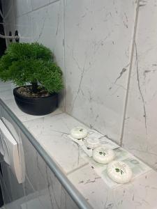 a bathroom counter with a plant and three white towels at Motel restoran Sunce in Sremska Kamenica