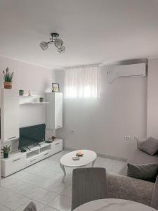 a white living room with a couch and a table at Motel restoran Sunce in Sremska Kamenica