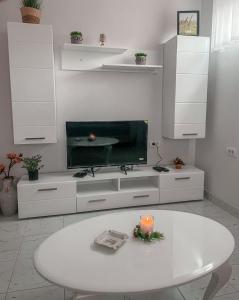 a white living room with a table and a tv at Motel restoran Sunce in Sremska Kamenica