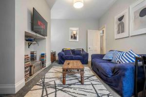 uma sala de estar com um sofá azul e uma mesa em Beautiful Apartment with Parking em Hexham