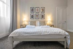 um quarto branco com uma cama grande e 2 candeeiros em Beautiful Apartment with Parking em Hexham