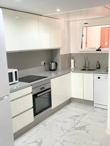 a white kitchen with white cabinets and a microwave at Casa Malibu El Rincon Pool view Playa Flamenca in Playa Flamenca