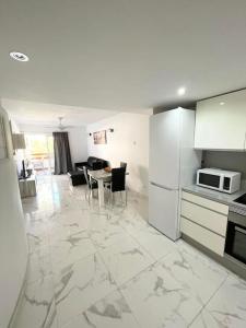a kitchen with white appliances and a table with chairs at Casa Malibu El Rincon Pool view Playa Flamenca in Playa Flamenca
