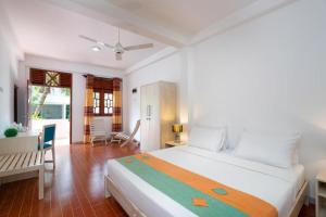 a bedroom with a large white bed and a desk at Star Light Villa in Unawatuna