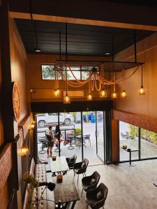 una stanza con tavoli e sedie e una grande finestra di Hostel Friends Station & Cafe a Pattaya Sud