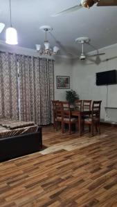 uma sala de estar com uma mesa de jantar e cadeiras em 6 Bedroom private home in Dha Lahore- Phase1 Entire House em Lahore