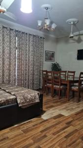 1 dormitorio con 1 cama, mesa y sillas en 6 Bedroom private home in Dha Lahore- Phase1 Entire House en Lahore