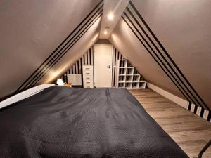 a bedroom with a black bed and a staircase at Ferienwohnung „Zur Eule“ in Hessisch Oldendorf