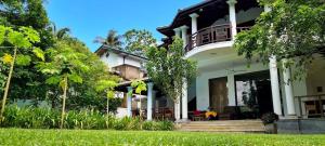 una grande casa bianca con portico e alberi di Star Light Villa a Unawatuna