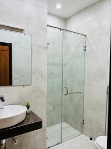 a bathroom with a glass shower and a sink at The Gateway islamabad in Islamabad