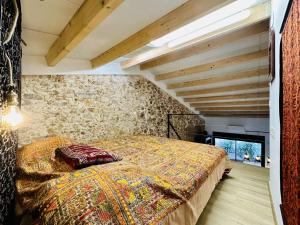 a bed in a room with a stone wall at Pecher CostaBravaSi in Sant Feliu de Guíxols