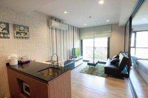 a kitchen and living room with a sink and a couch at Let’s me sea@Rain Cha-am in Cha Am