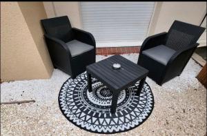 two chairs and a table in a living room at Appartement Love Room/Jacuzzi in Toulouse +3 photos