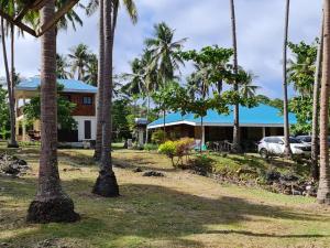 a house with palm trees in front of it at Camotes Palanas Beach Stay in Himensulan
