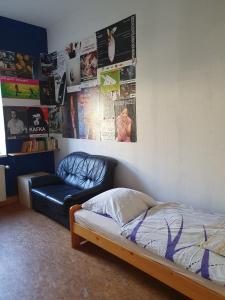 a bedroom with a bed and a couch and posters at Kulturschutzgebiet in Dresden