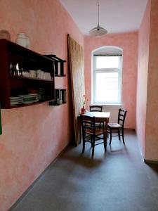 a dining room with a table and chairs and a window at Kulturschutzgebiet in Dresden