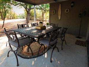 una mesa de patio con sillas y un pastel. en Bushveld Jewel - Close to Kruger en Hoedspruit