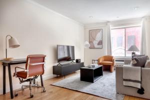 - un salon avec un bureau et un canapé dans l'établissement Nolita 1BR w Elevator Roof Deck nr SoHo NYC-907, à New York