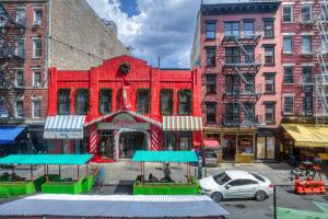 un bâtiment rouge au milieu d'une ville dans l'établissement Nolita 1BR w Elevator Roof Deck nr SoHo NYC-907, à New York