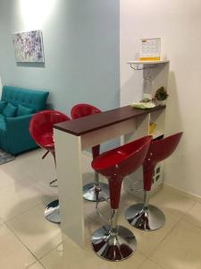 a bar with four red bar stools in a room at New Paradigm Residence @1-3/4pax in Johor Bahru
