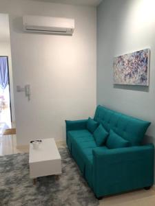 a living room with a blue couch and a table at New Paradigm Residence @1-3/4pax in Johor Bahru