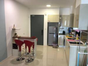 a kitchen with two red stools and a counter at New Paradigm Residence @1-3/4pax in Johor Bahru