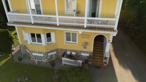 an overhead view of a yellow house with a porch at Gästehaus Gertrude in Velden am Wörthersee