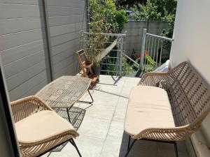 3 chaises en osier et une table sur une terrasse dans l'établissement Superbe meulière familiale, à Rosny-sous-Bois