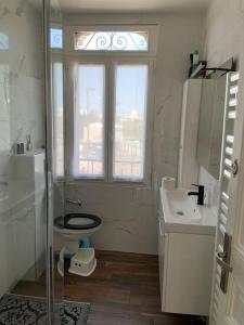 La salle de bains est pourvue de toilettes, d'un lavabo et d'une fenêtre. dans l'établissement Superbe meulière familiale, à Rosny-sous-Bois