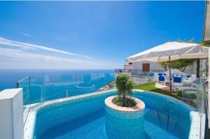 a swimming pool with a potted plant and an umbrella at Holidays dream Praiano in Praiano