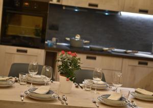 una mesa con platos y vasos y una planta en ella en Appartamenti Astra, en Livigno