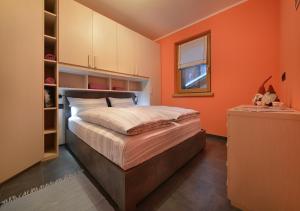 a bedroom with orange walls and a large bed at Appartamenti Astra in Livigno