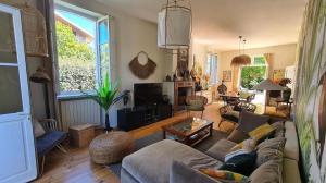 een woonkamer met een bank en een tafel bij Magnifique Villa 500m Océan et 5 min Lac Hossegor in Capbreton