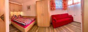 - une chambre avec un canapé rouge et un fauteuil rouge dans l'établissement Chalet - Urlaub bei Freunden, à Wagrain