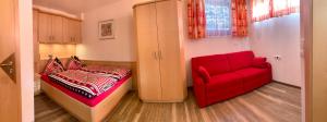 a bedroom with a red couch and a red chair at Chalet - Urlaub bei Freunden in Wagrain