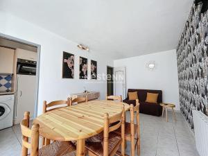 een keuken en eetkamer met een houten tafel en stoelen bij 3192- T2 à 400m de la plage in Argelès-sur-Mer