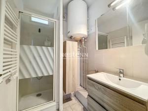 een badkamer met een douche, een wastafel en een spiegel bij 3192- T2 à 400m de la plage in Argelès-sur-Mer