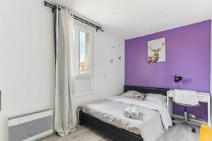 een slaapkamer met een bed met een paarse muur bij Appartement au calme et proche des transports in Créteil