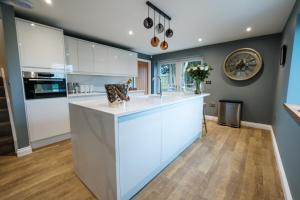 a kitchen with white cabinets and a large island at Bramley Brook Cottage 5* Luxury in Whalley