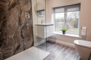 a bathroom with a glass shower and a window at Bramley Brook Cottage 5* Luxury in Whalley +26 photos