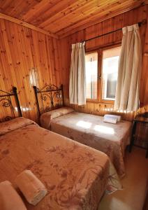 Camping Orgiva في أورخيفا: غرفة نوم بسريرين ونافذة