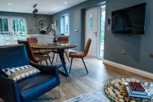 Bramley Brook Cottage 5* Luxury في وهلي: غرفة معيشة مع طاولة وكراسي