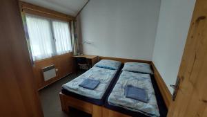a small bedroom with two beds and a desk at Apartmány U Potoka in Dolní Moravice