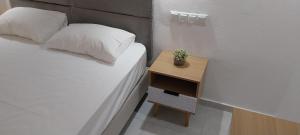 ein kleines Bett mit einem Nachttisch und einer Topfpflanze darauf in der Unterkunft Euro Park Hotel in Astris