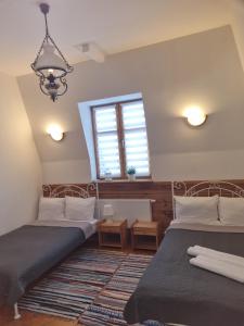 2 Betten in einem Zimmer mit Fenster in der Unterkunft Hotelik ze śniadaniami "KUR" Myszyniec-Kurpie in Myszyniec