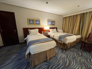 麥加的住宿－فندق الصفوة البرج الثالث 3 Al Safwah Hotel Third Tower，酒店客房设有两张床和窗户。