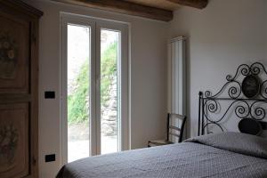 1 dormitorio con cama y ventana grande en La Pezzuola 53, en Sopralacroce