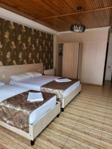 a bedroom with two beds and a wall at Hotel Elio in Batumi